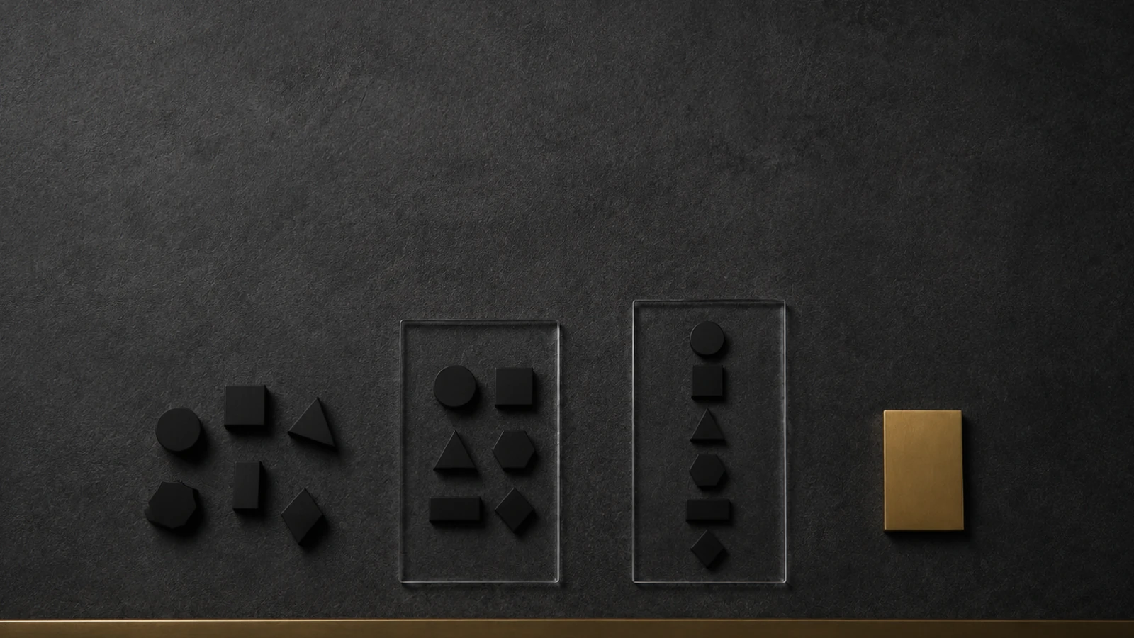 Black geometric tiles on a dark felt board: a loose scatter of them at left, the same shapes sorted into two clear trays in the middle, and one brass plate set apart at right.